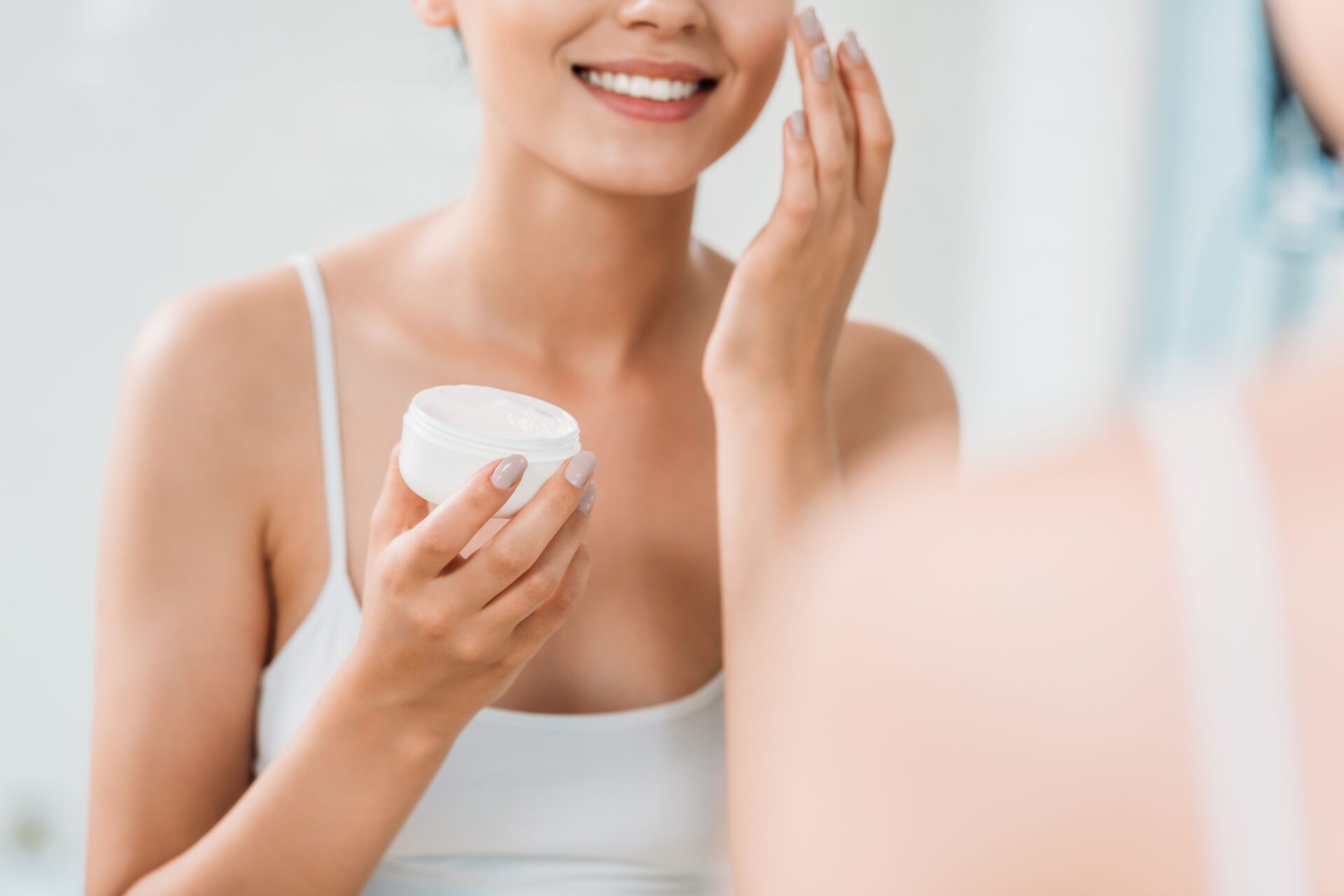 A woman is looking at her face in the mirror